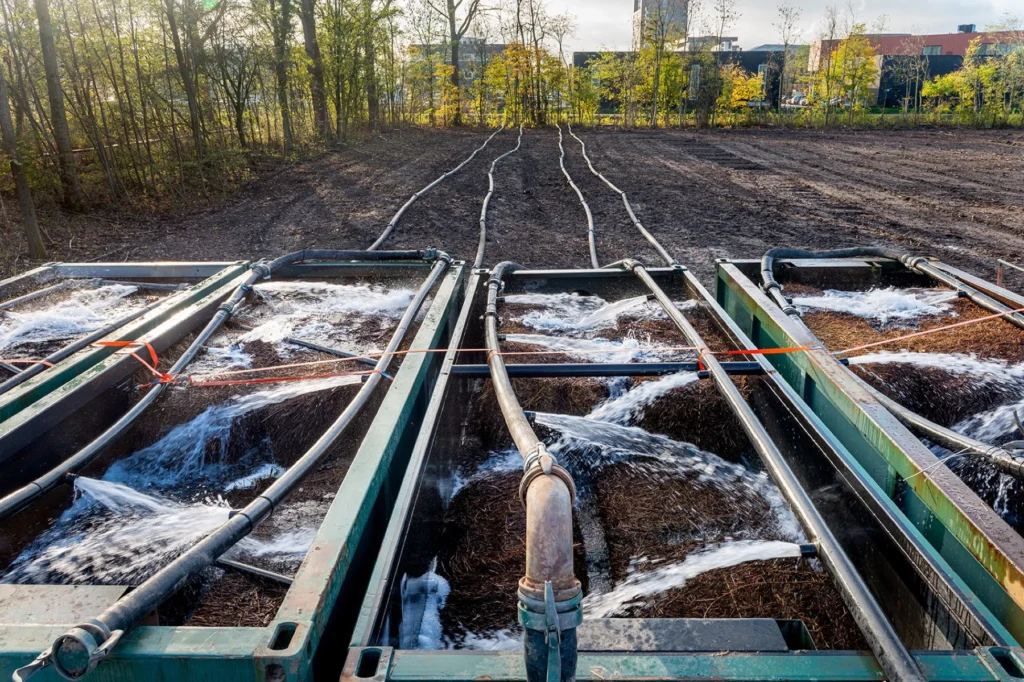 Filterbemaling met pompen en leidingen langs een bouwput